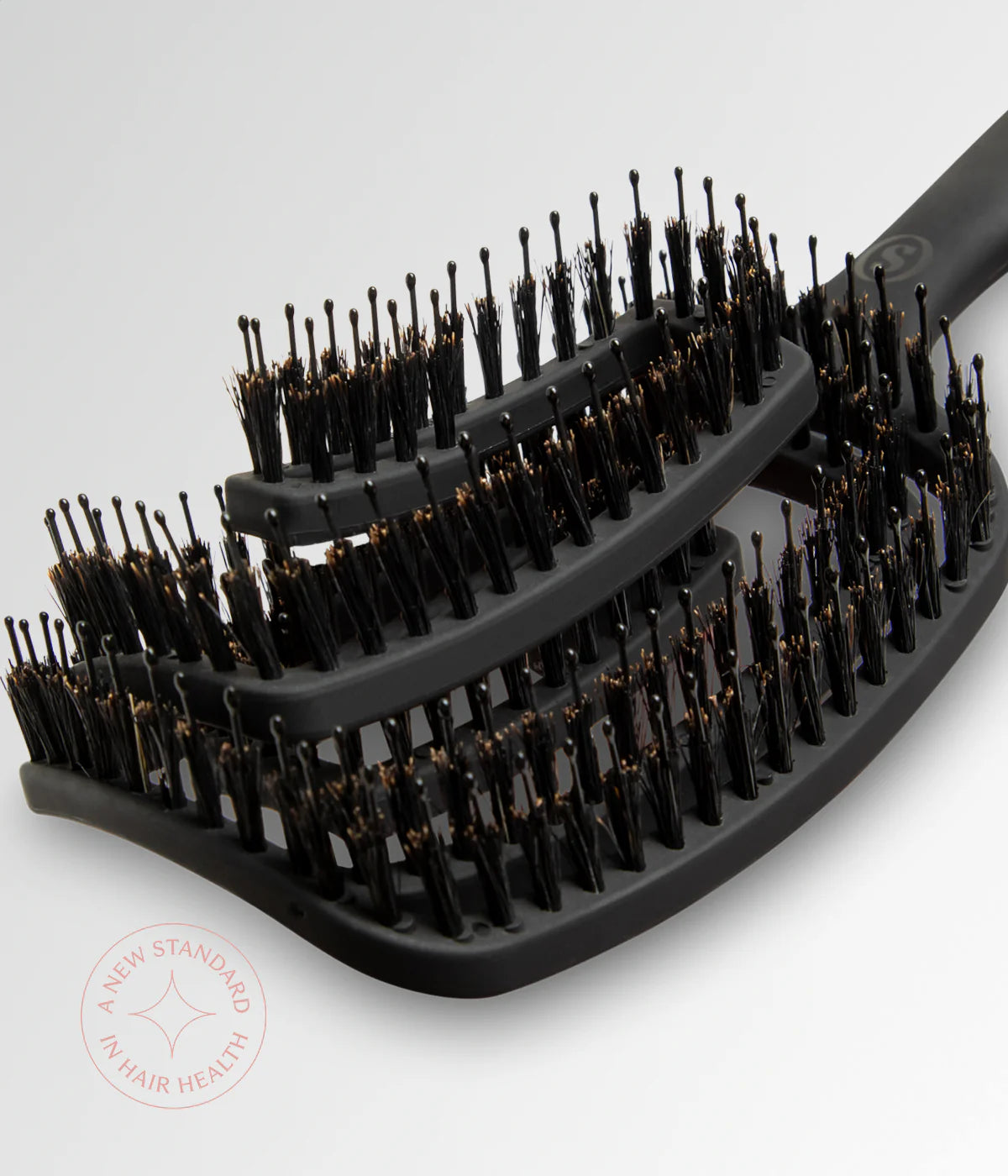 Black vent brush showing multi-row bristles on curved base