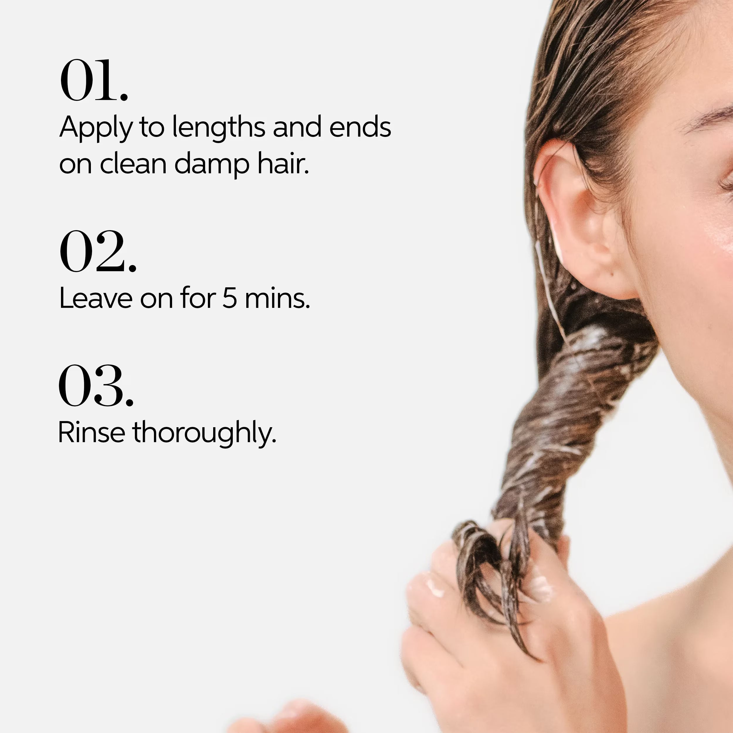 Hair mask application: hands applying product to damp hair lengths