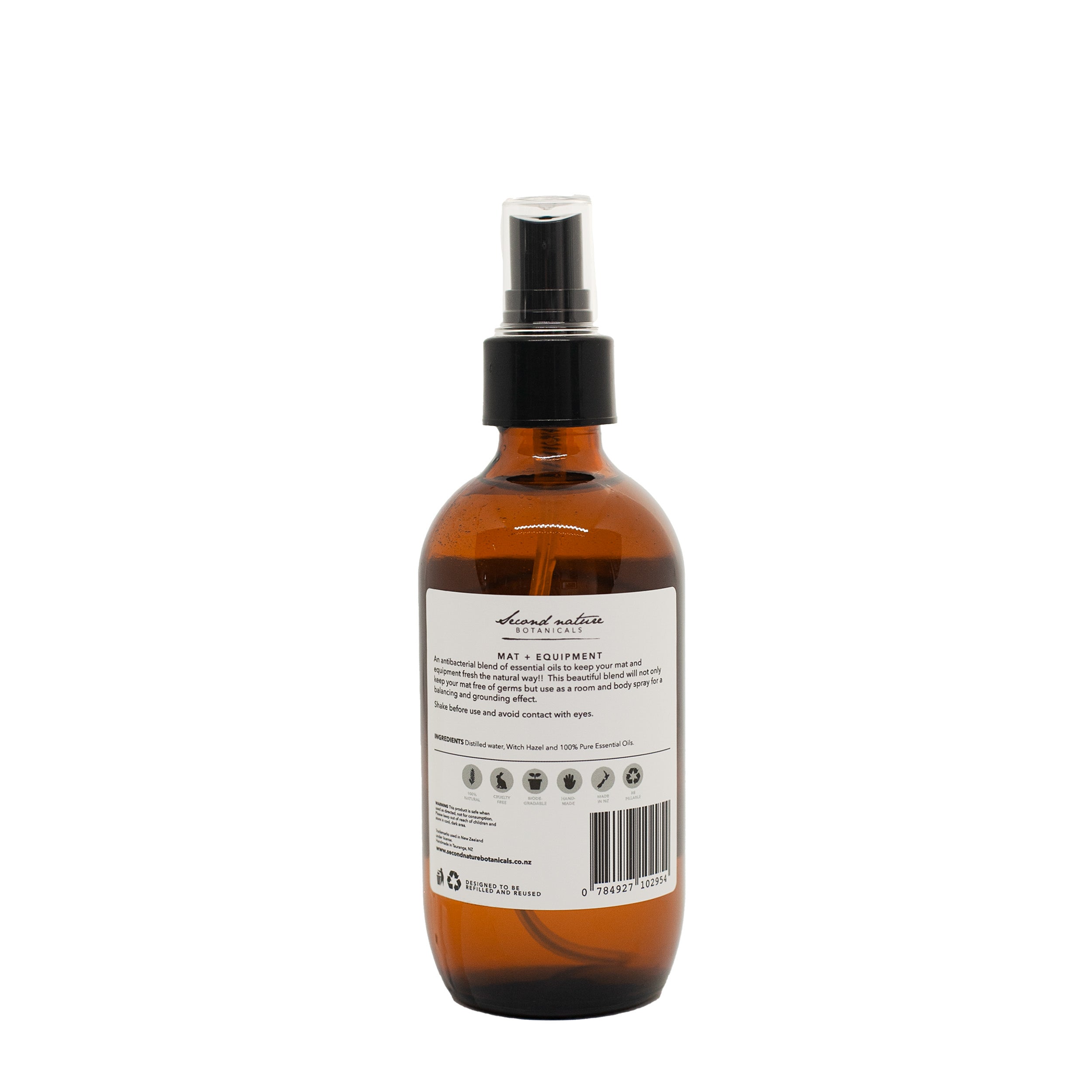 Yoga mat spray bottle with amber liquid, black pump, back label text