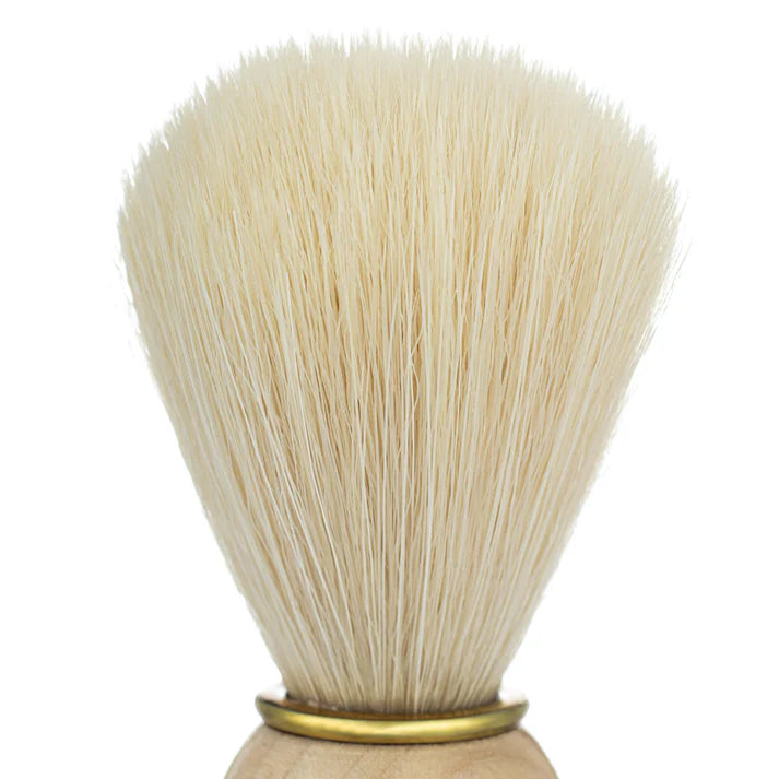 Close-up of synthetic shaving brush bristles on light wood handle