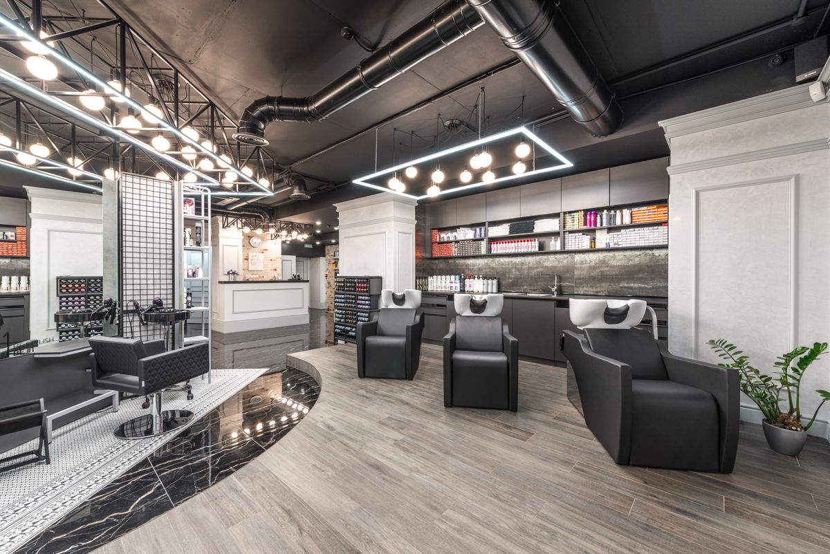 Modern hair salon interior with styling chairs and wash basins